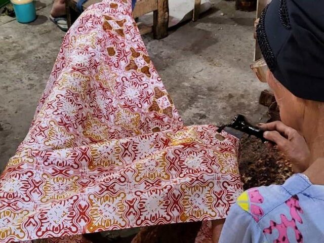 A Woman is designing batik