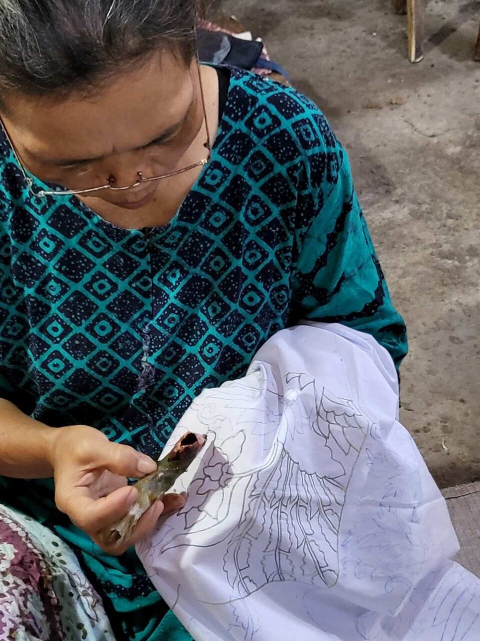 A woman worker is designed batik on fabric