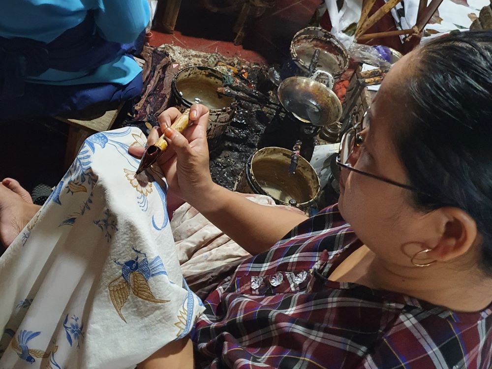 A woman is designing batik